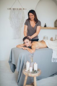 Woman enjoying a relaxing spa massage surrounded by soothing candles for ultimate relaxation.